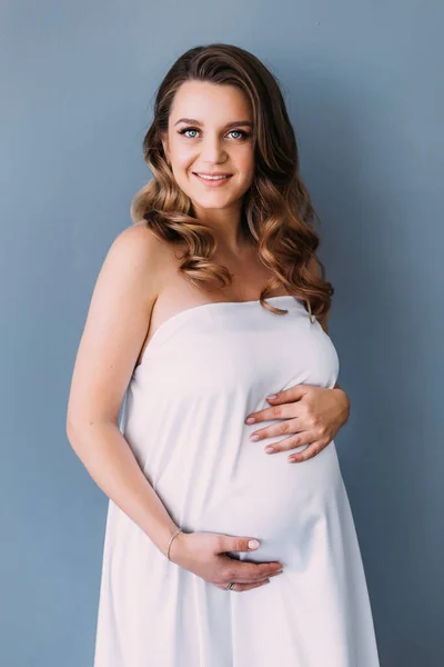 Jong Glimlachende Zwangere Vrouw Met Mooie Witte Satijnen Stof Staan — Stockfoto