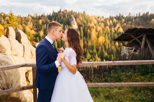 美しい自然 岩の背景に山の上でキスを愛し 花嫁と新郎のカップル — ストック写真
