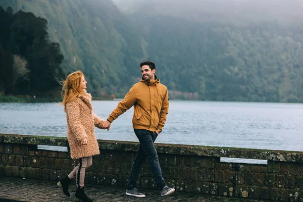在湖边散步 那个家伙和那个女孩手牵手看着对方 山脉和湖泊 — 图库照片