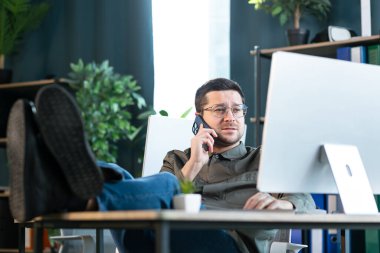 Telefon ofis masasında oturan işadamı