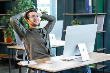 İşe ara verdim. Rahat iş adamı sandalyede dinleniyor, iş yerinde arkasını yaslıyor, olumlu adam el ele tutuşuyor, ofis içi.