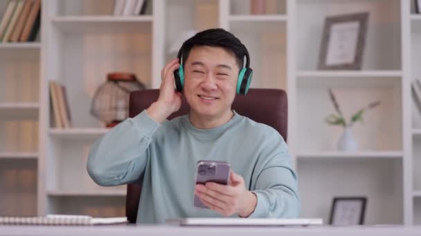 Boldog Ázsiai Férfi Visel Fejhallgató Asztalnál Modern Otthoni Irodában Izgatott — Stock videók
