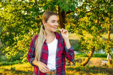 Kırmızı tişörtlü genç ve güzel bir kadın görünmez bir hizalayıcıyı tutuyor. Diş sağlığı ve güven konsepti. Metin için yerler