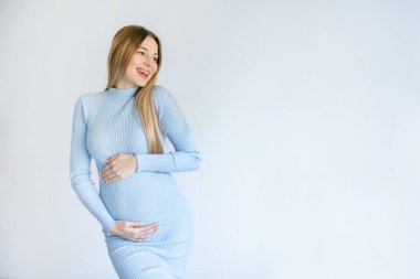 Hamile kadın karnına dokunuyor. Karnını okşayan hamile bir kadın. Sağlıklı Gebelik Konsepti, Beyaz arka planda Duran Gravid Kadın, Tam boy portre