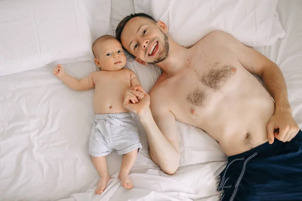 Ευτυχισμένος Νεαρός Πατέρας Ένα Μωρό Στο Κρεβάτι Στο Σπίτι Έχοντας — Φωτογραφία Αρχείου