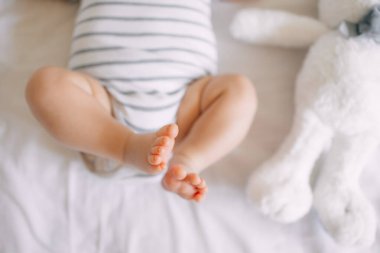 Yeni doğmuş bir bebeğin küçük ayağı. Yeni doğmuş beyaz bir battaniyenin yumuşak ayakları. Yeni doğmuş bir bebeğin ayak ve ayak parmaklarını kapatın. Makro fotoğrafçılık.