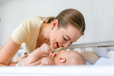 Genç anne bir sabah yeni doğmuş bebeğiyle evde oynuyor. Çocuk, bebek, ebeveynlik, çocukluk, hayat, annelik, annelik kavramı.