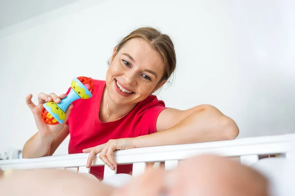 Χαρούμενη Μητέρα Κουδουνίστρα Παιχνίδι Και Χαμογελώντας Ενώ Παίζει Χαριτωμένο Νεογέννητο — Φωτογραφία Αρχείου