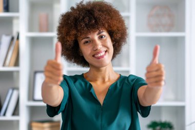 Kendine güvenen, güzel bir kadın baş parmağını kaldırıyor. İş, finans ve istihdam, başarılı kadın girişimciler konsepti.