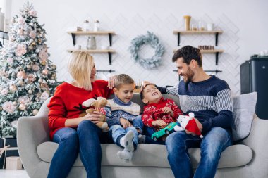 Mutlu aile Noel için dekore edilmiş oturma odasında.