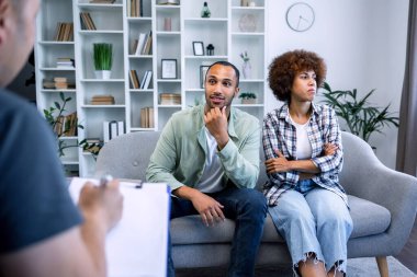 Psikolog mutsuz duygusal çifte danışmanlık yapıyor, karı koca klinikte kavga ediyor. Zihinsel sorunlar, terapi ve tedavi, profesyonel tıbbi destek