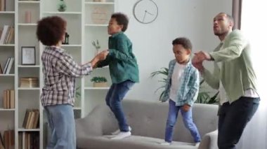 Modern stüdyo salonunda müzik eşliğinde dans etmekten çok mutlu bir aile. Heyecanlı, evli ve çocuklu genç bir çift, evde boş vakitlerini geçiriyorlar..