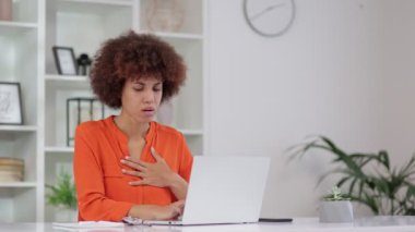 Göğüs gerilmesinden muzdarip kıvırcık saçlı Afro-Amerikan kadın portresi, merkez ofiste kalp krizi. Göğsünü elleriyle tutan siyah kadının acil tıbbi müdahaleye ihtiyacı var.