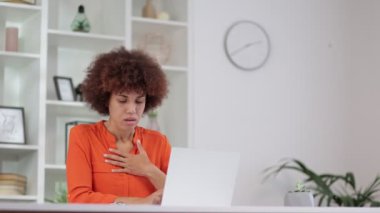 Göğüs gerilmesinden muzdarip kıvırcık saçlı Afro-Amerikan kadın portresi, merkez ofiste kalp krizi. Göğsünü elleriyle tutan siyah kadının acil tıbbi müdahaleye ihtiyacı var.