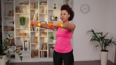 Güzel, Afro-Amerikan atletik, tozlu ve üzerinde dambıllar olan güzel bir kız. Spor, sağlıklı yaşam tarzı.