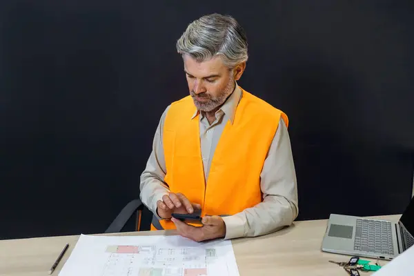 Electronics Design Factory: Portrait of Handsome Male Engineer Wearing Safety Vest Working on phone, Developing architect project
