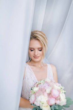 Gelin, evlenmeden önce beyaz perdeden dışarı bakıyor. Gözlerini kapatıyor.