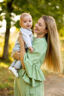 Genç ve güzel anne çocuğuyla dışarıda oynuyor..