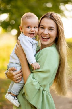 Kafkasyalı anne ve küçük çocuk birlikte oynuyorlar. Birlikte eğleniyorlar. Sarıl ve kameraya bak. Mutlu oğul ve anne dışarıda gülüyor. Aile yaşam tarzını seviyorum.