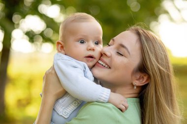 Mutlu anne ve tatlı gülümseyen bebek. Pozitif insani duygular, duygular, doğal yaşam tarzları. Aile geçmişi.