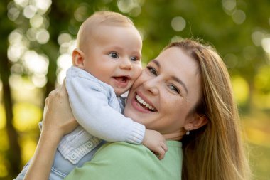 Anne ve bebek. Doğal annelik ve annelik kavramı. Güzel kadın ve küçük bebek yeşil doğada birlikte mutlular. Dışarıda çocuklu bir anne..