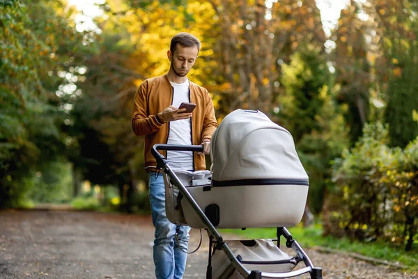 Father Scrolling Cell Phone Pushing Pram Messaging Using App — Stock Photo, Image