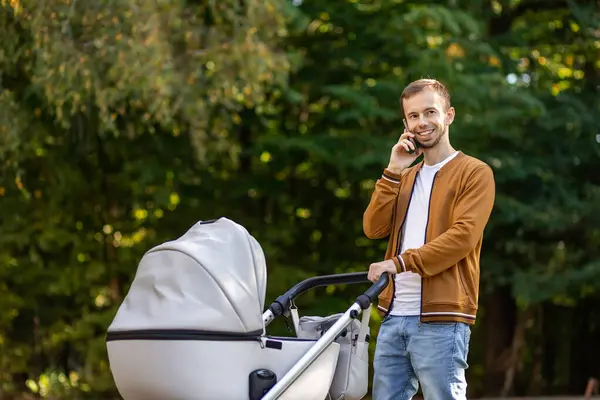Smiling Young Adult Father Pushing Baby Stroller Walking Park Warm — Stock Photo, Image