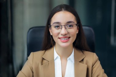 Ofis masasında oturan kendine güvenen iş kadını çevrimiçi kamera toplantısına bak.