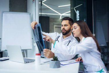 Göğüs röntgeni ya da MRI görüntüsünü klinik dolabında inceleyen konsantre nörolog.