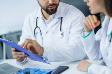 Tıbbi ekip hasta teşhisinde veya kan örneklerinde oturup tartışıyor.