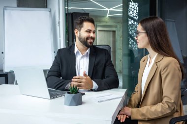 Avukat ya da emlakçı, müvekkil için danışmanlık yapar. İş adamı ve Avrupalı bir kadın dizüstü bilgisayarla ofis masasında projeyi tartışıyorlar. İnsanlar birlikte çalışır..