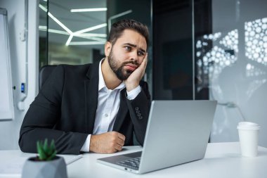 Uykulu, yorgun, bitkin bir yetişkin enerji eksikliği hisseder. Ofisteki motivasyonsuz işçi