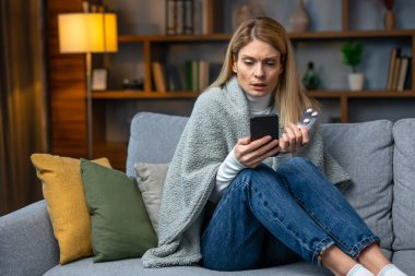 Sick  girl sitting on couch, holding thermometer and calling family doctor for counseling, free space