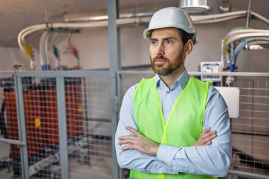 man worker engineering standing confident with working suit and safety helmet in front of factory.
