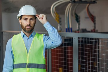 Engineer in Hard Hat and Safety Wear look at camera. Confident Attractive Mechanic of Machine Inspection