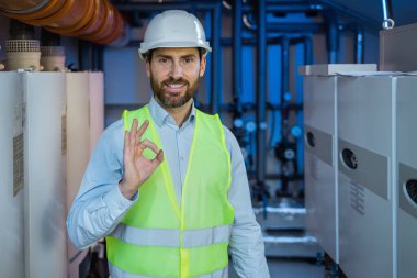 caucasian man wearing contractor uniform and safety helmet happy with big smile doing ok sign