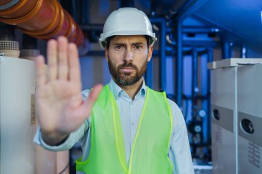 workman wearing safety vest and helmet making stop gesture with his hand denying a situation that could wrong.