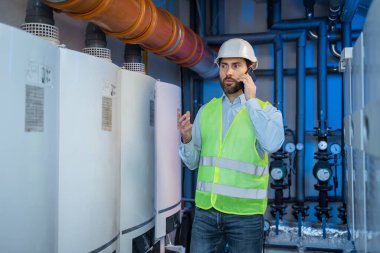 worker in the heating room worried calling to resolve problem. Maintenance and inspection.