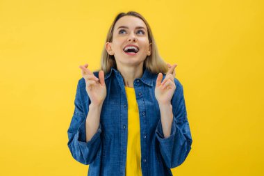 Sarı arka planda duran gülümseyen genç kız şans dilemek için şans diliyor.