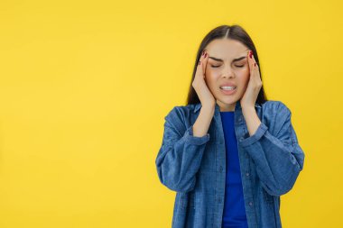 Elleri başının üstünde olan güzel genç bir kadın migren ağrısı çekiyor..