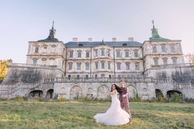 Yeni evlilerin düğünü şatonun arka planına karşı. Bir çift doğadaki antik bir sarayın arka planında dans ediyor..