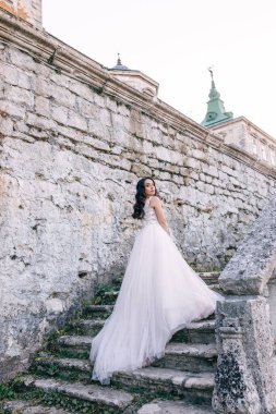Gelin, kalenin merdivenlerinden, dağda bekleyen kocasına çıkıyor. Düğün gününde.