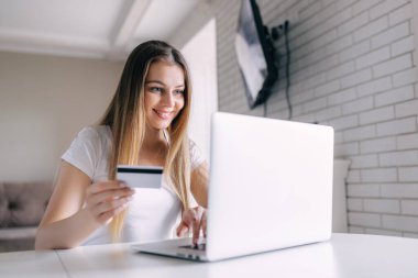laptop ve kredi kartı ile gülümseyen iş kadını