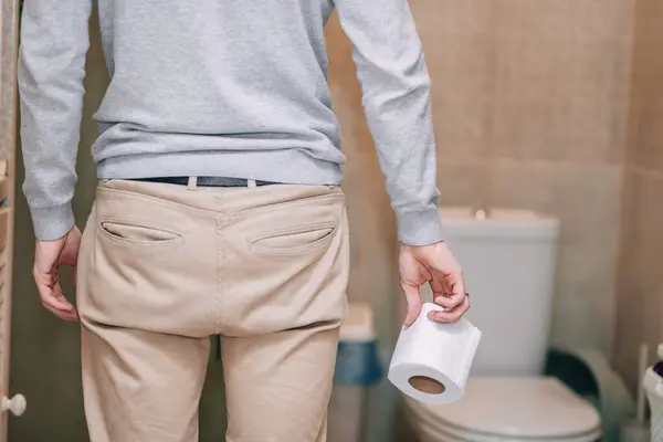 stock image male hand holding toilet paper before entering the bathroom or toilet