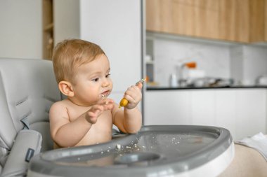 Bebek kirli yemek yer. Mutfakta beslenmek için sofrayı dağıtır.