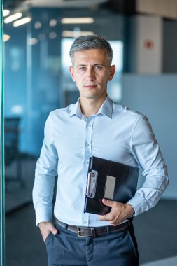 Ofis ortamında kendine güvenen bir profesyonel liderlik ve başarı bildiren bir pano tutuyor.