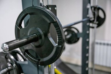 Spor salonunda ağırlık plakaları tutan halterin detaylı bir görüntüsü..