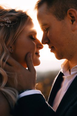 Gün batımında gelin ve damadın portresini kapat.