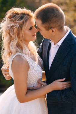 Çekici bir çift, yeni evliler, öpüşmeden önce hassas bir an. Düğün açık havada..