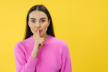 Genç, çekici, esmer, samimi duyguları olan, sessiz bir jest yapan kadın. Sırrı sarı arkaplanda izole et